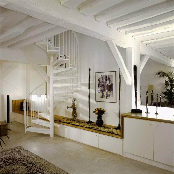 gaité paris appartement rénovation volume duplex triplex escalier monumentale métal blanc tout étage poutre apparente blanche peinte meuble sur mesure blanc bois carrelage beige banc statuette déco africaine coloniale